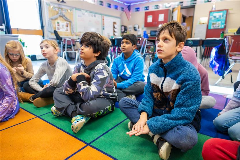 A teacher plays a ukulele for her students